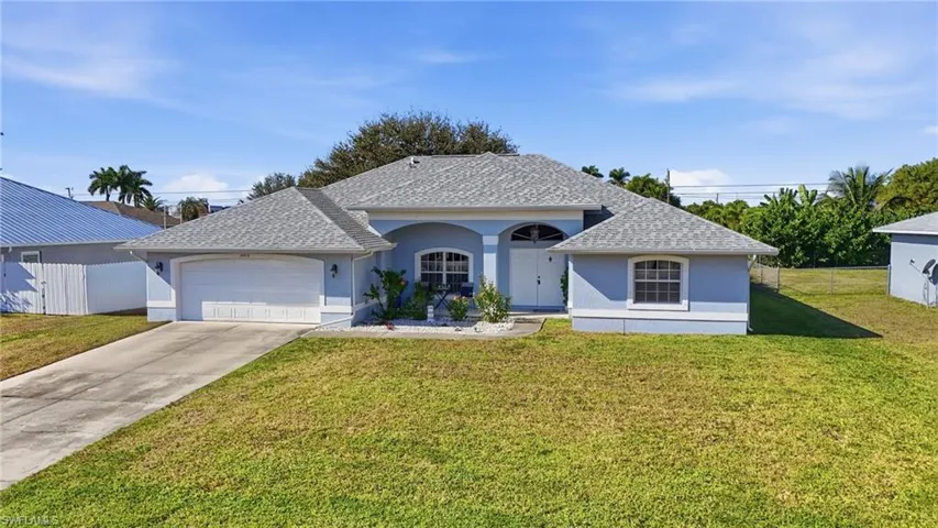 View of front of property with stucco siding, driveway, a shingled roof, and a garage