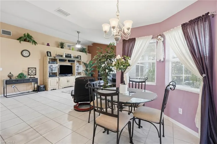 Dining area featuring light tile patterned floors, a chandelier, and ceiling fan