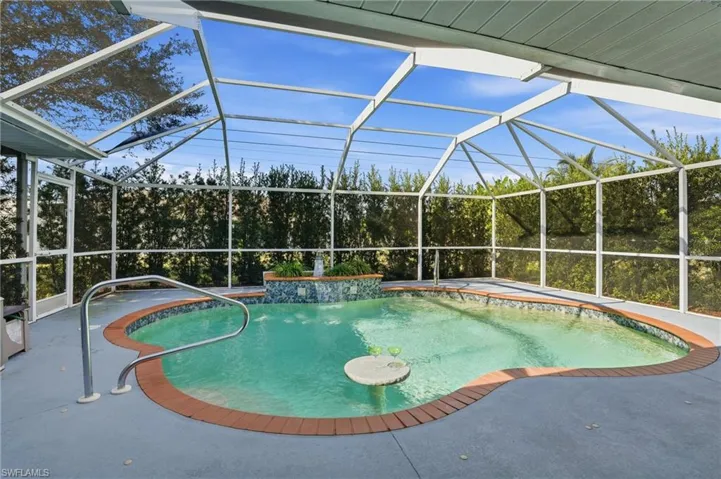 Outdoor pool featuring a sunroom, glass enclosure, and a patio