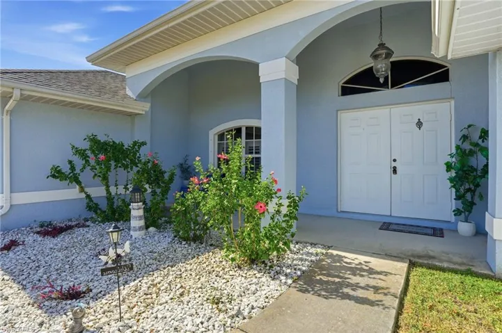 Entrance to property featuring stucco siding, roof with shingles, and a porch