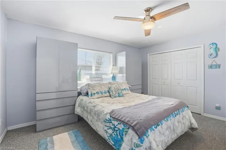 Bedroom with carpet flooring, ceiling fan, and a closet