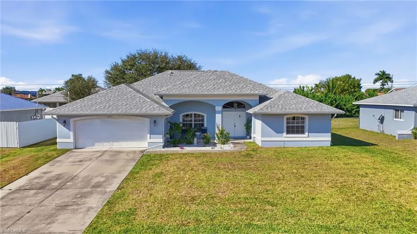 View of front of house featuring roof with shingles, stucco siding, and a front lawn