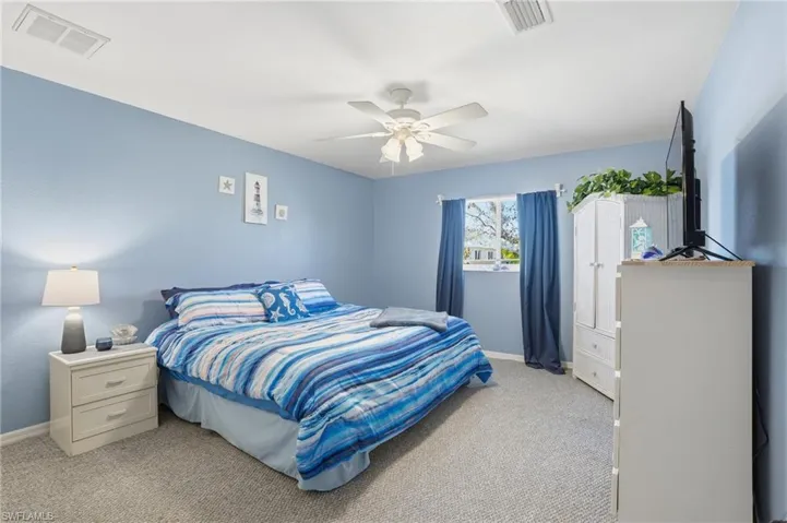 Bedroom featuring light colored carpet and a ceiling fan