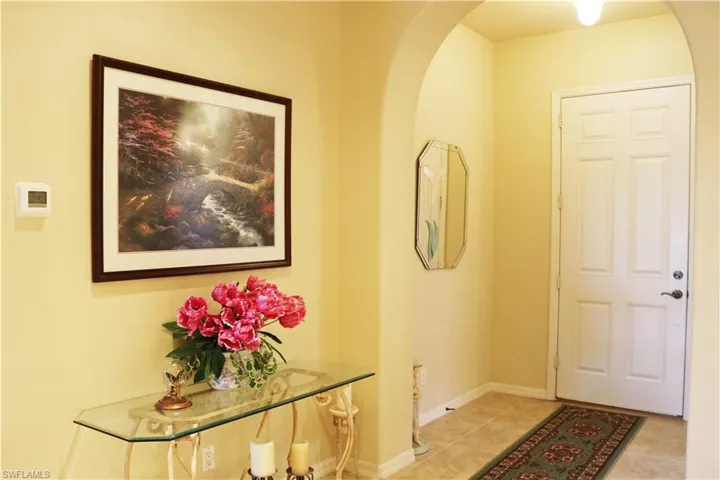 Entryway with arched walkways and light tile patterned floors