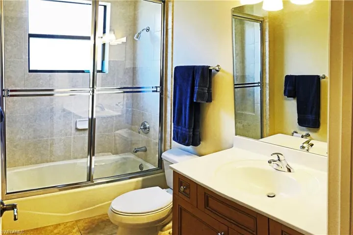 Guest Bathroom featuring enclosed tub / shower combo, and tiled floor.