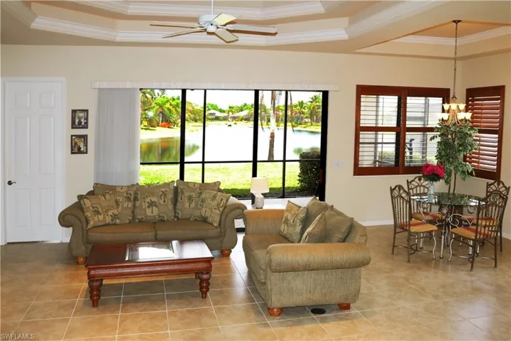 Living area with beautiful lake view, featuring a tray ceiling, and a healthy amount of sunlight