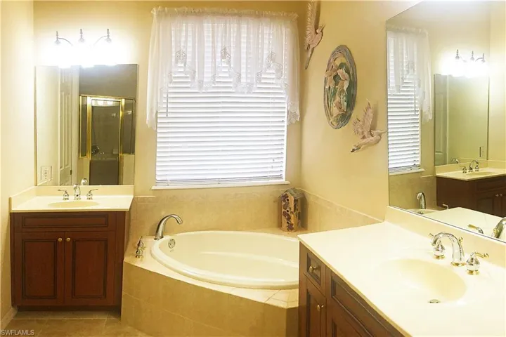 Owner's bath with a garden tub, a shower stall, and two vanities.