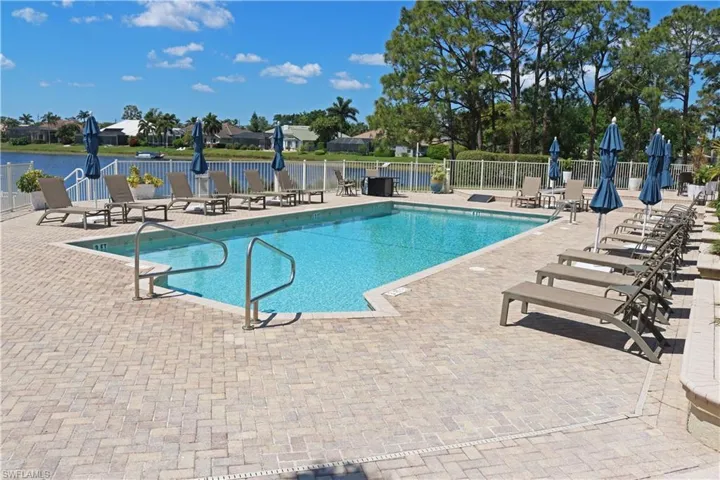 Community pool featuring fence and a patio area