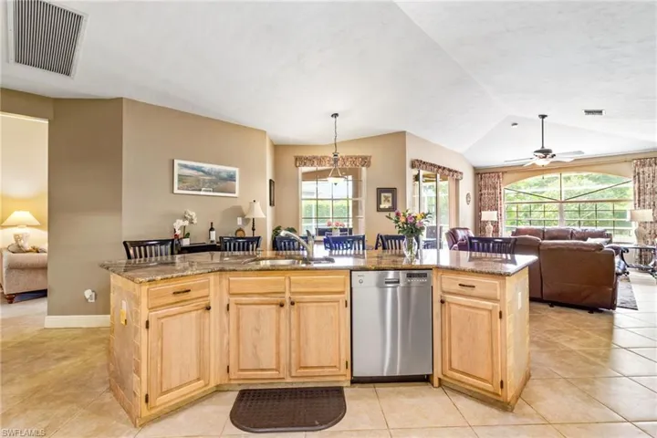 Kitchen with sink, plenty of natural light, an island with sink, and stainless steel dishwasher