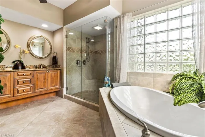 Bathroom featuring tile floors, independent shower and bath, and vanity
