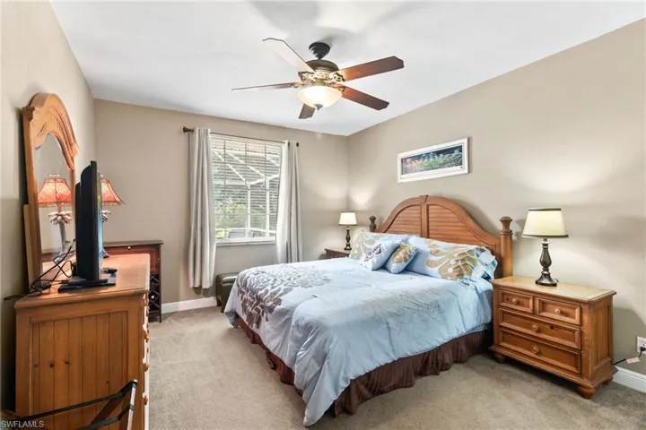 Carpeted bedroom featuring ceiling fan
