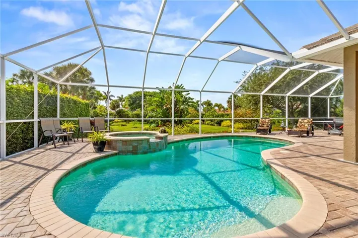 View of swimming pool with a patio, a lanai, and an in ground hot tub
