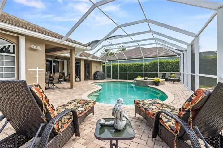 View of swimming pool with a patio area and glass enclosure