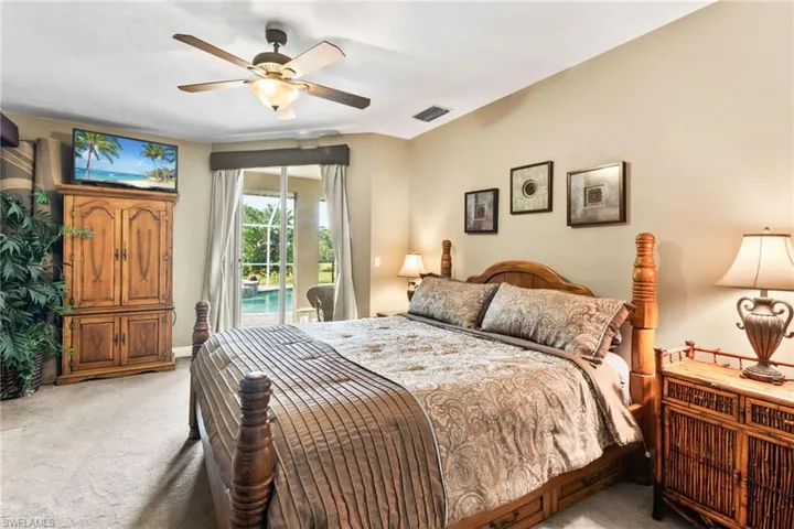 Carpeted bedroom featuring ceiling fan and access to outside