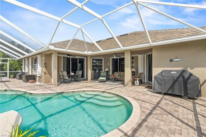 View of swimming pool featuring a patio, a lanai, a grill, and ceiling fan