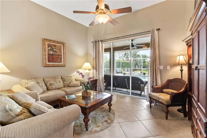 Living room with ceiling fan and light tile flooring