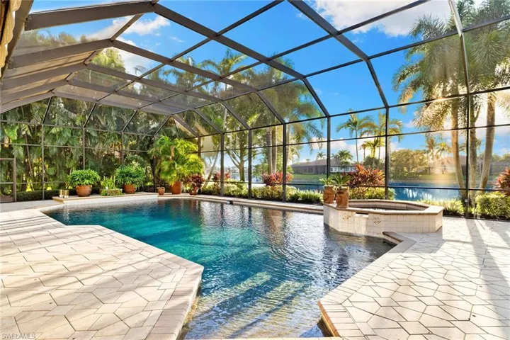 View of swimming pool with glass enclosure, a pool with connected hot tub, a patio, and a sunroom