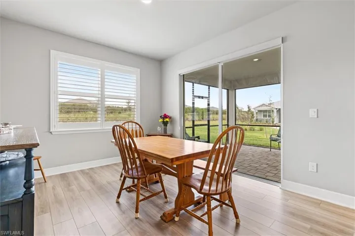 Dining space featuring light vinyl plank floors and baseboards