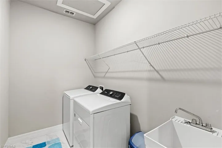 Washroom with washing machine and dryer and tile flooring