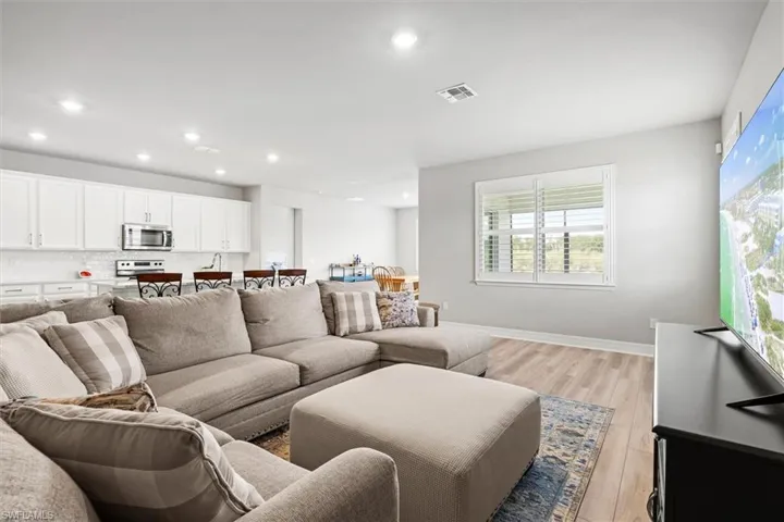 Living area with light vinyl plank floors and recessed lighting