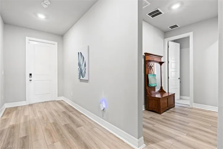 Corridor featuring light vinyl plank flooring and recessed lighting