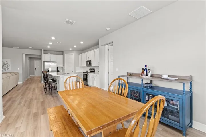 Dining space with light vinyl plank flooring and recessed lighting