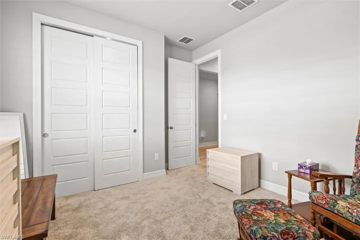 Living area featuring light colored carpet and baseboards