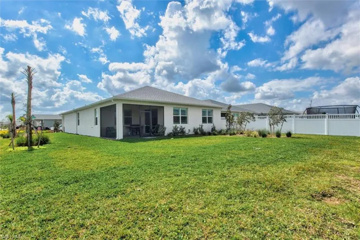 Back of property with stucco siding and a sunroom