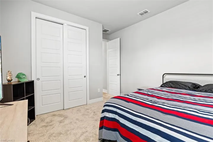 Bedroom featuring light colored carpet and a closet