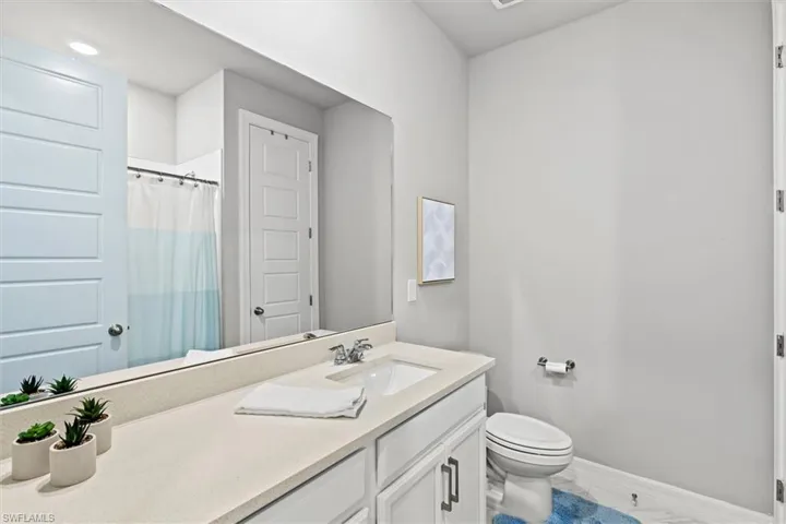 Full bath with a shower with curtain and vanity