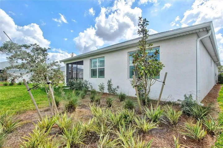 View of property exterior with a sunroom, stucco siding, and a yard
