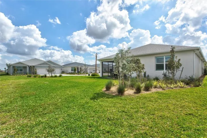 View of grassy yard with a sunroom