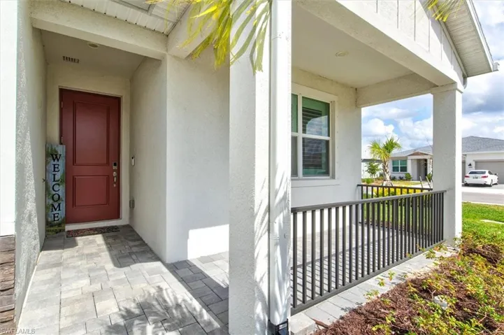 View of exterior entry featuring stucco siding and covered porch