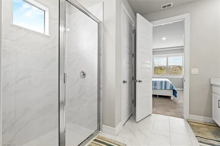 Full bathroom with healthy amount of natural light, ensuite bath, vanity, and tile floors