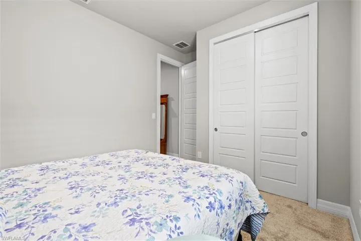 Carpeted bedroom featuring a closet and baseboards