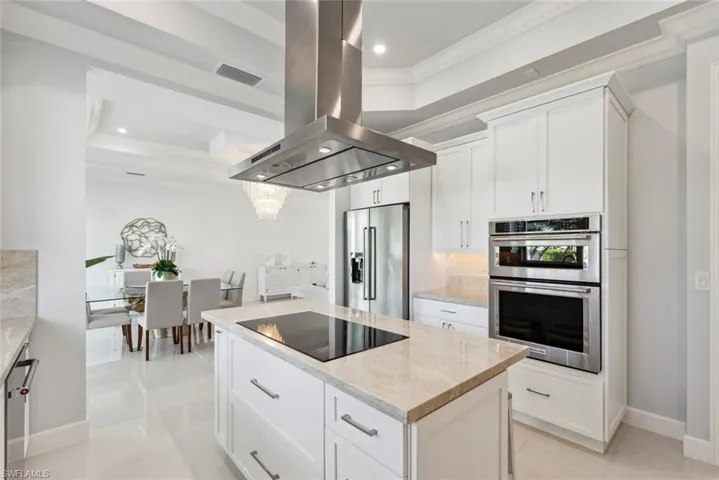 Kitchen with visible vents, ornamental molding, tasteful backsplash, stainless steel appliances, and island range hood