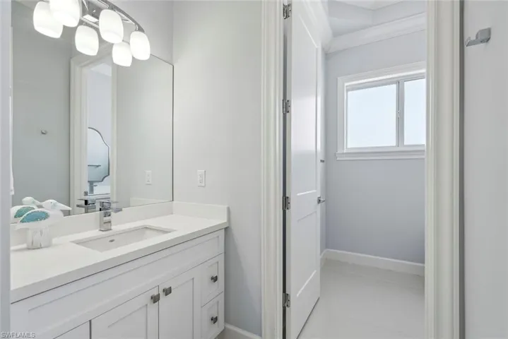 Bathroom featuring vanity, baseboards, and ornamental molding