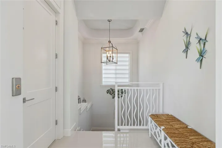 Mudroom with a chandelier, visible vents, a raised ceiling, and ornamental molding