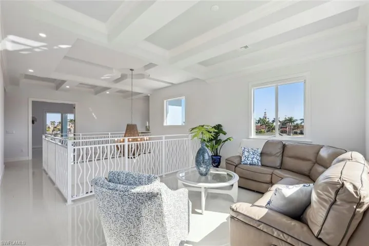 Living room featuring baseboards, coffered ceiling, beam ceiling, recessed lighting, and ornamental molding