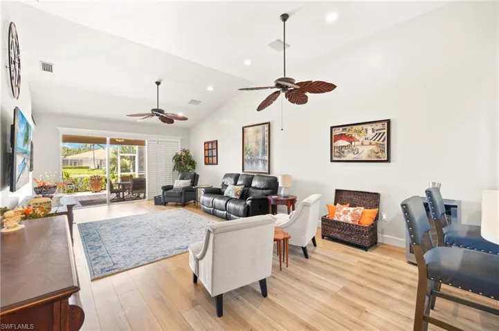 Living room featuring a ceiling fan, light wood-style flooring, lofted ceiling, and recessed lighting