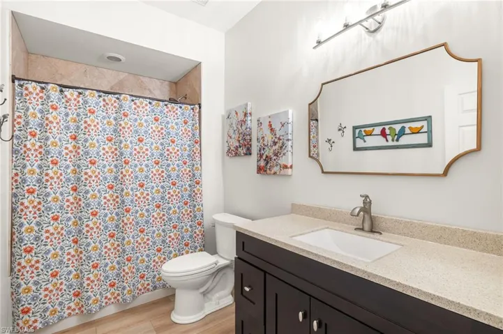 Full bath featuring vanity, wood finished floors, and a shower with curtain