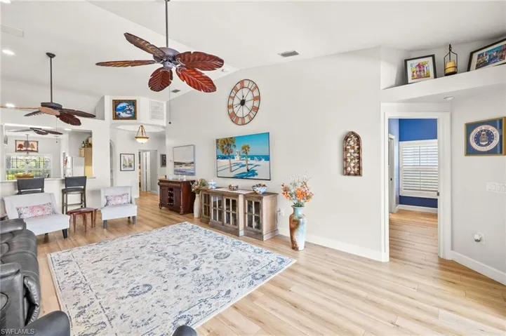 Living room with ceiling fan, light wood-style flooring, lofted ceiling, and recessed lighting