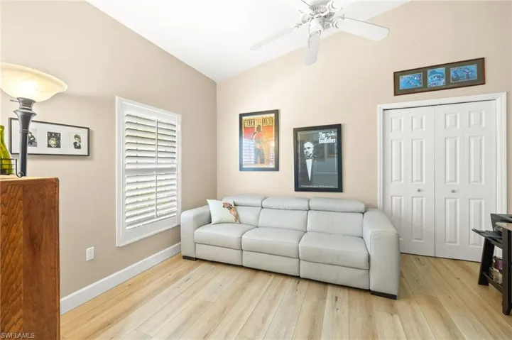 Living room with wood finished floors, a ceiling fan, and high vaulted ceiling