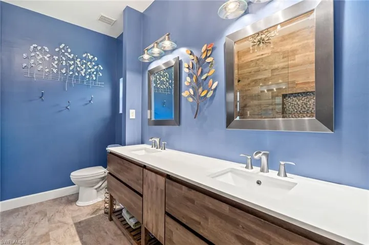 Bathroom with double vanity and toilet