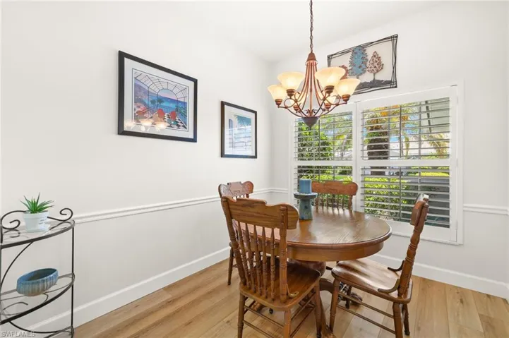 Dining space with light wood finished floors and a chandelier