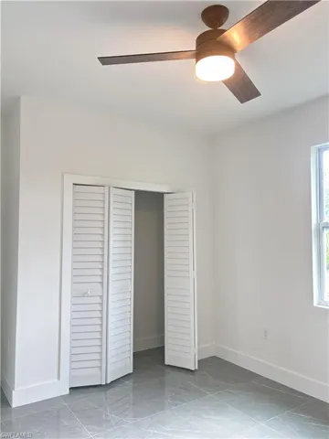 Unfurnished bedroom featuring baseboards, a closet, and ceiling fan