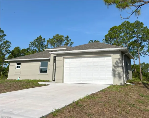Ranch-style house featuring driveway, stucco siding, and an attached garage