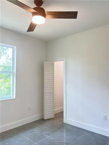 Unfurnished room with baseboards and ceiling fan