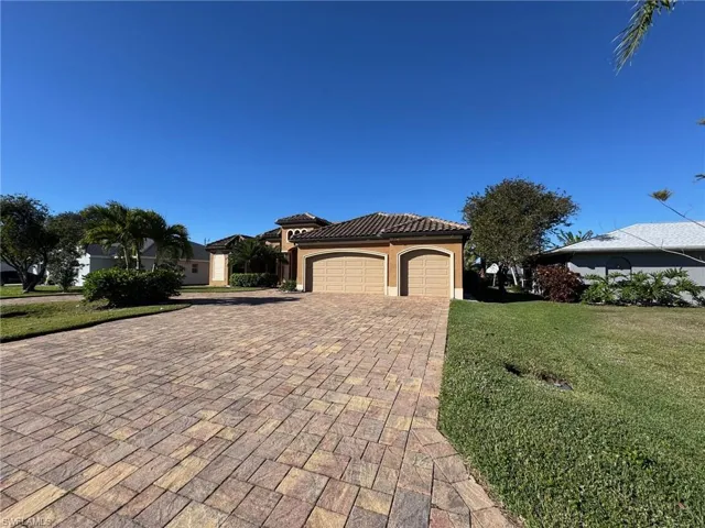 View of front of property featuring a front yard and a garage