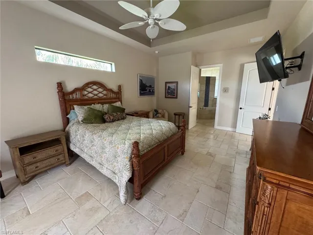 Bedroom with ceiling fan and a tray ceiling
